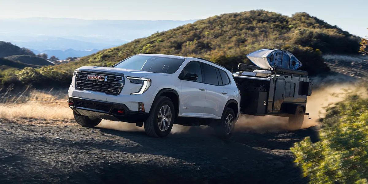 Exterior View of the 2026 GMC Acadia Mid-Size SUV Towing a Trailer